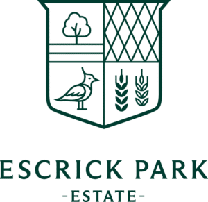 Logo of Escrick Park Estate featuring a green shield divided into quadrants with a tree, a bird, a lattice pattern, and wheat. ESCRICK PARK is written below with the word -ESTATE- underneath.
