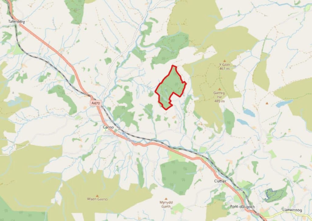 A map of the area surrounding Carno, Wales, with a red outline highlighting a specific area of land northeast of the village.